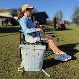Woman sitting at kids footy with Sunza Original Cooler Backpack in Seafoam Mist beside her on the grass