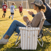 Woman sitting at kids footy with Sunza Original Cooler Backpack in Drift Sand beside her