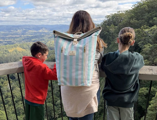 A family walking a hinterland rainforest trail to a waterfall these school holidays