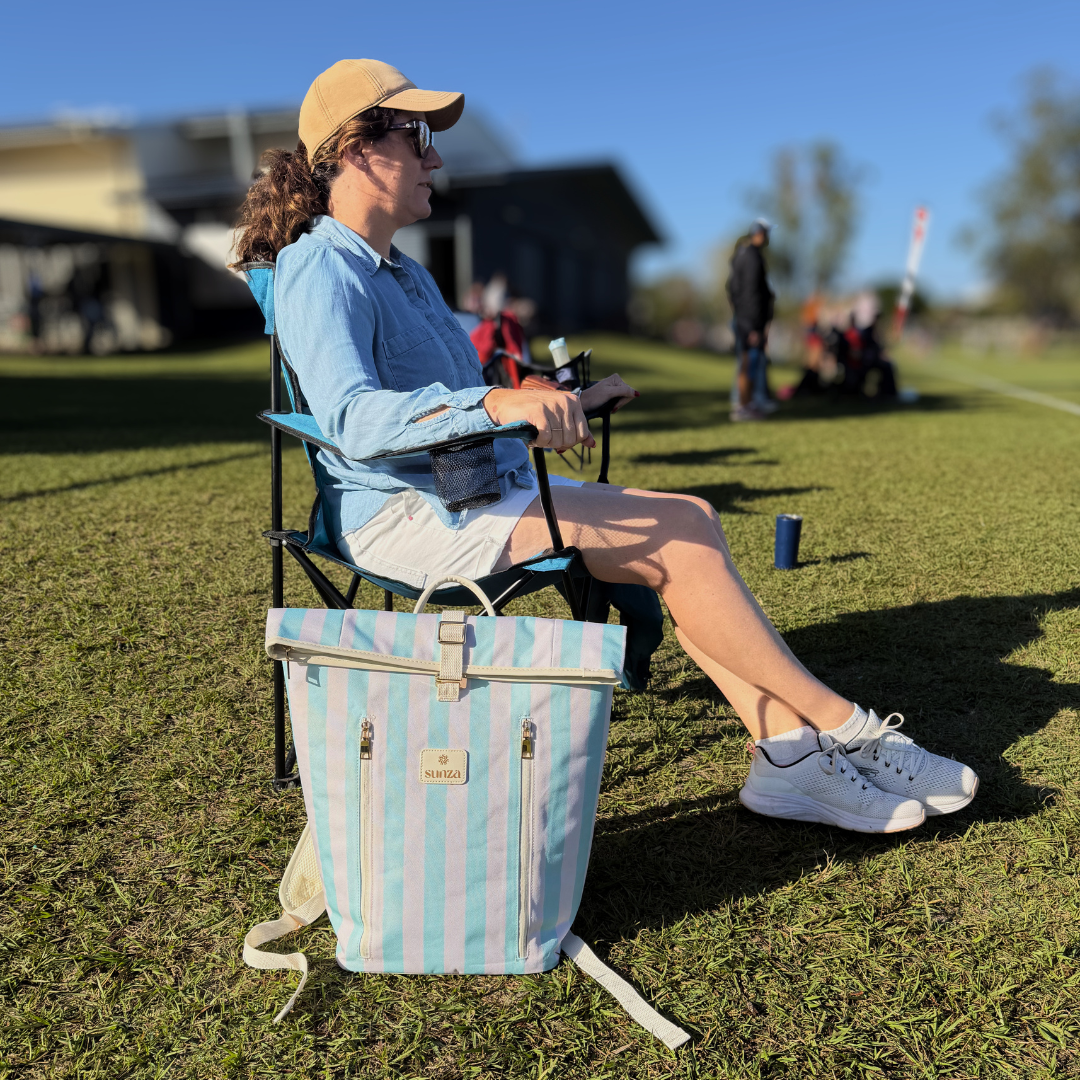 Woman sitting at kids footy with Sunza Original Cooler Backpack in Seafoam Mist beside her on the grass
