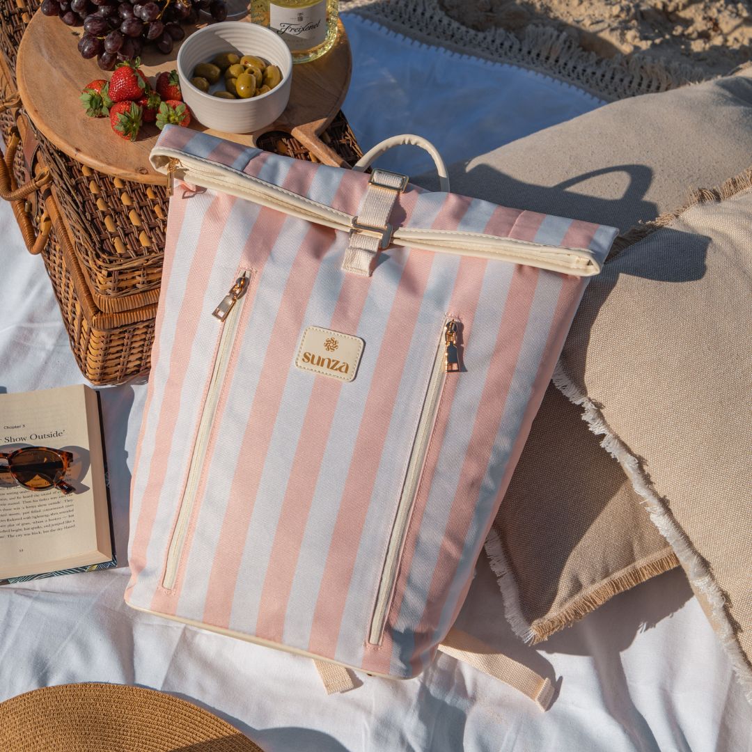 Sunza Original Cooler Backpack in Sunset Blush at a beach picnic alongside a wicker basket — stylish insulated bag for picnics Australia